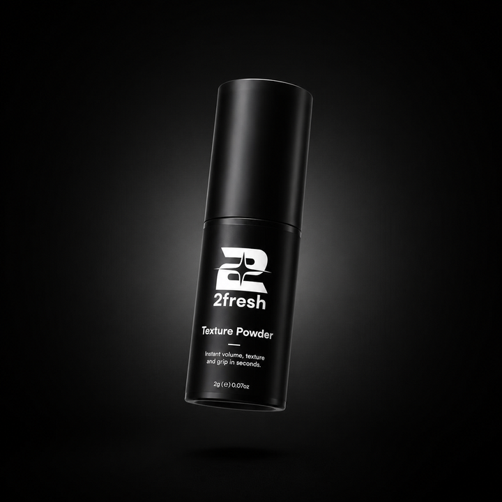 A black cylindrical bottle of 2fresh Texture Powder, featuring a white logo and text, floating against a dark black background with a subtle spotlight effect.