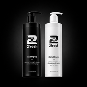 Two 2fresh haircare bottles on a black background: a black pump bottle labeled Shampoo and a white pump bottle labeled Conditioner.