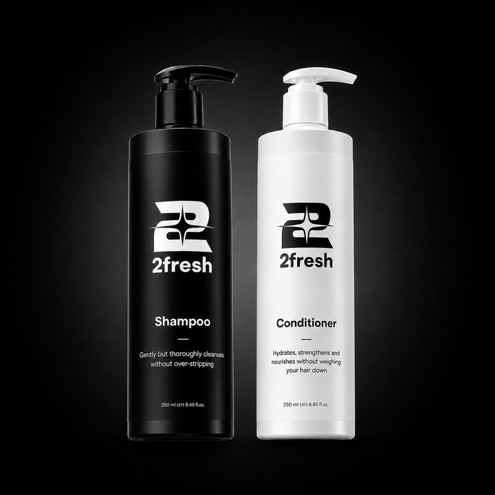 Two 2fresh haircare bottles on a black background: a black pump bottle labeled Shampoo and a white pump bottle labeled Conditioner.