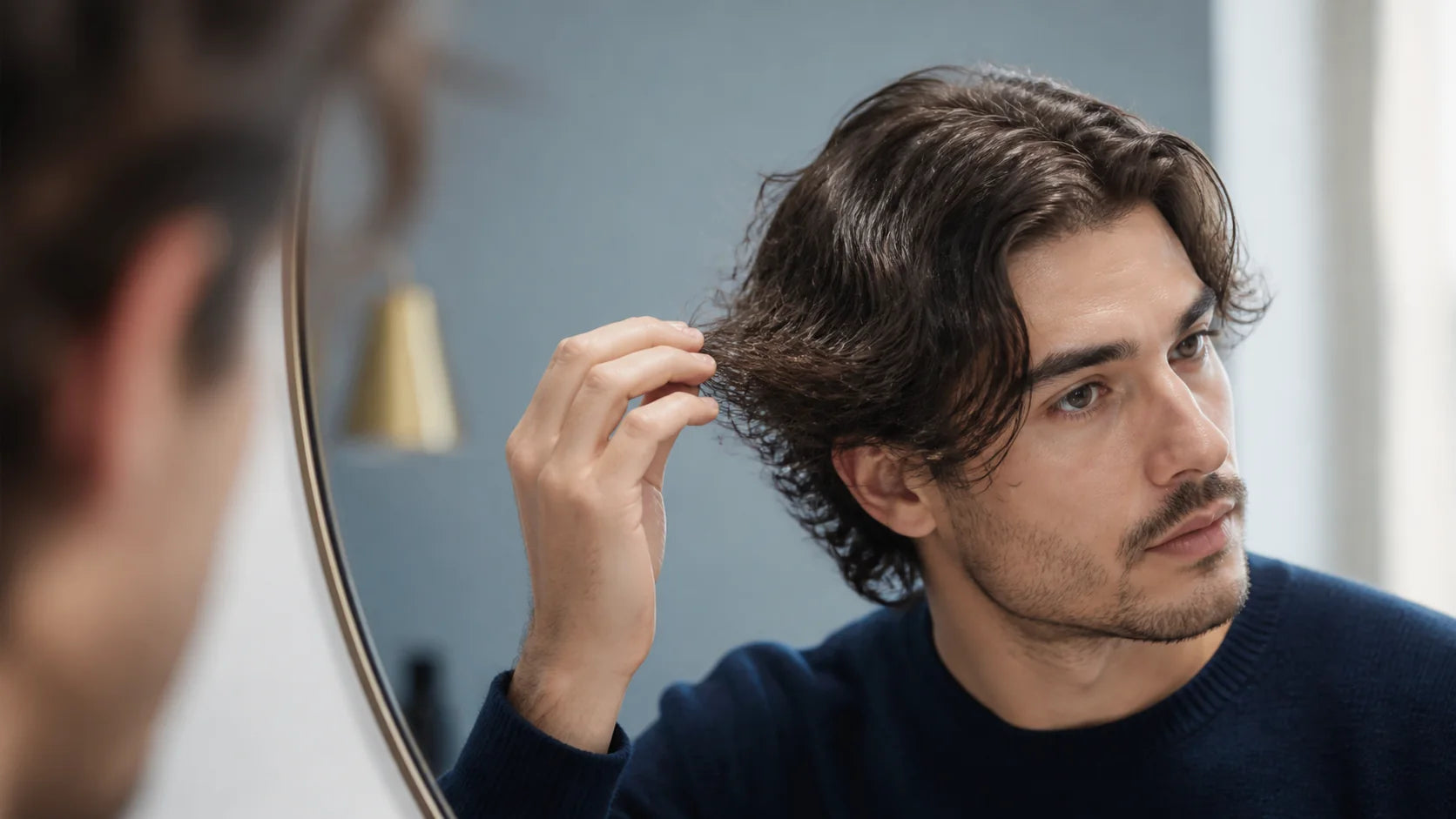 Man examining the condition and texture of his hair