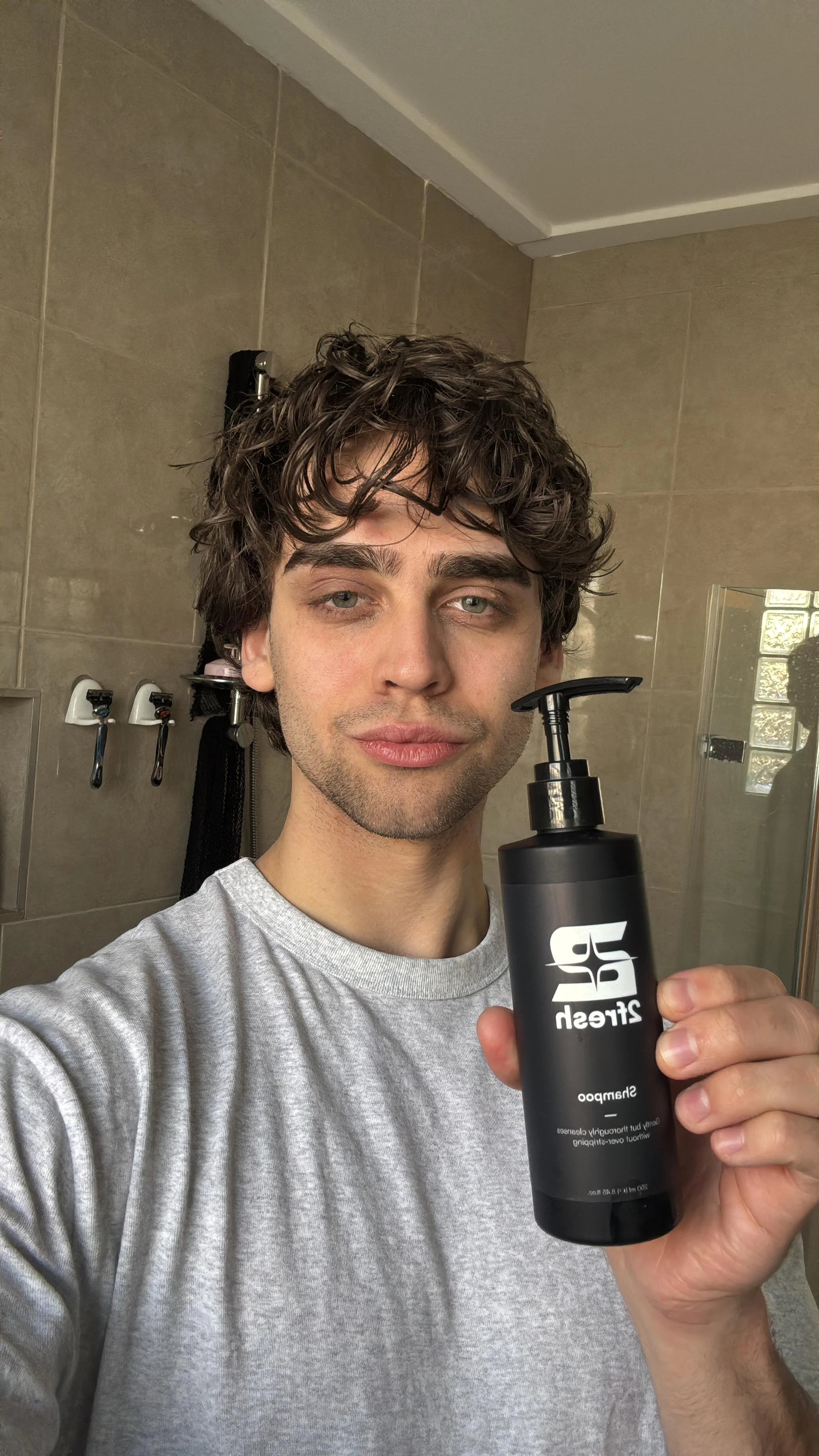 Man with wet textured hair holding 2Fresh Shampoo