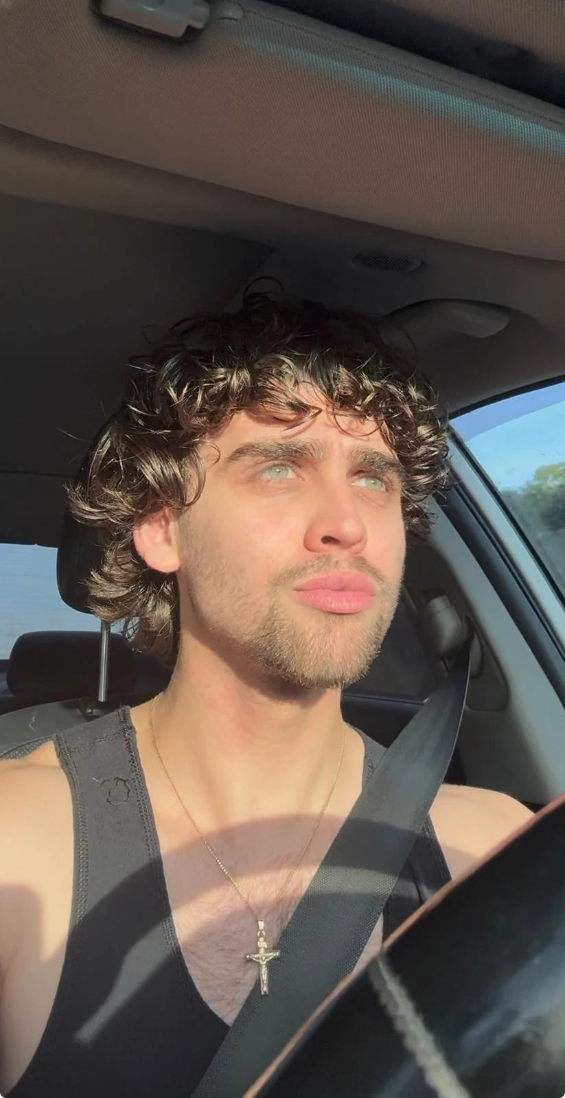 Man with curly hair in natural sunlight
