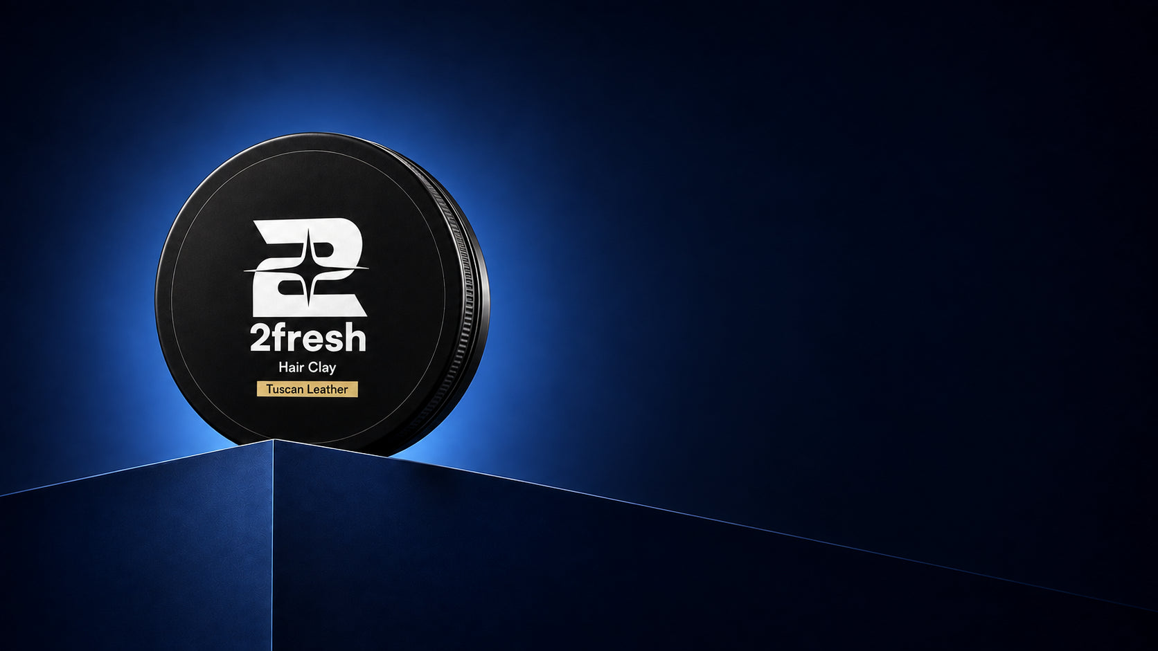 2Fresh Hair Clay in Tuscan Leather on a blue podium against a dark navy background
